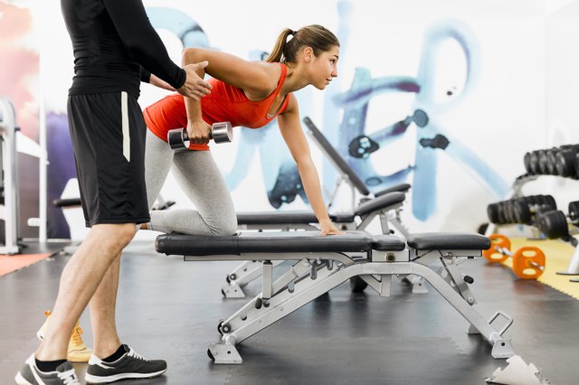 personal trainer working with a client in the gym doing rows