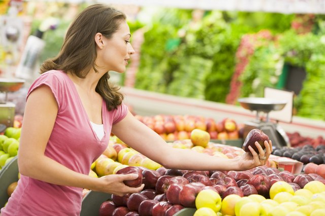 Woman shopping for apples at a grocery store