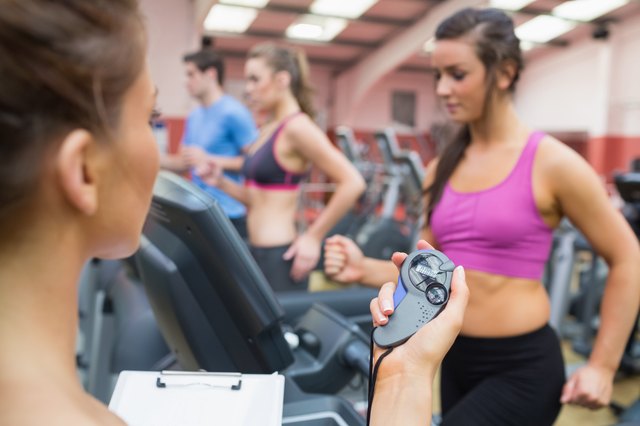 Instructor using stopwatch in gym