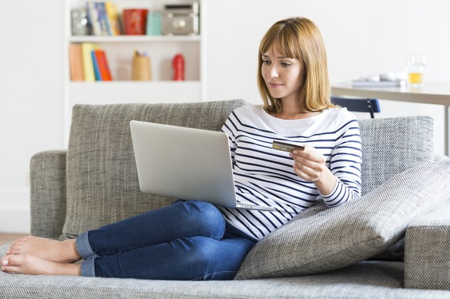 Thirty year old woman shopping using laptop and credit card