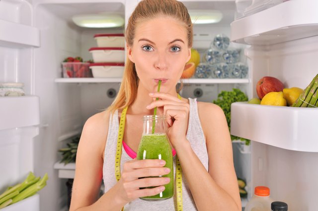 Young woman drinking green smoothie