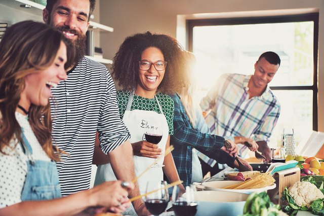 Group of diverse friends drinking and cooking