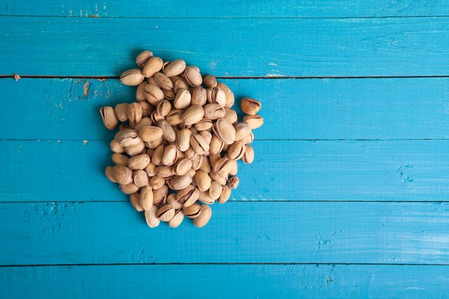 salted pistachios on a blue wooden table